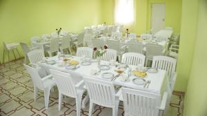 una sala de conferencias con mesas blancas y sillas blancas en Hotel VENUS en Tiflis