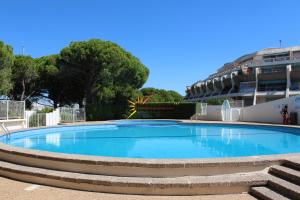 a large blue swimming pool in a building at Studio 237 Port Camargue, Piscine, Climatisation, 2 personnes in Le Grau-du-Roi
