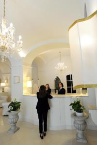 a woman standing in front of a counter in a room at Minori Palace in Minori