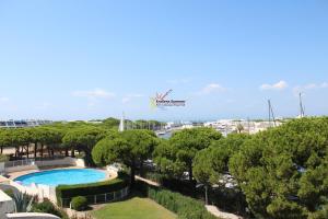a resort with a swimming pool and trees at Studio 237 Port Camargue, Piscine, Climatisation, 2 personnes in Le Grau-du-Roi