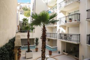 een binnenplaats met twee palmbomen voor een gebouw bij CANNES Palazzio in Cannes
