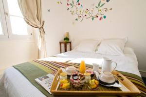 a tray with food and drinks on a bed at hotel de la plage in Piriac-sur-Mer