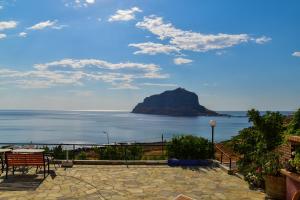 a patio with a view of the ocean and a mountain at Paraschou Guesthouse in Monemvasia