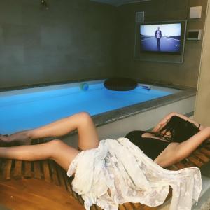 dos mujeres tumbadas en una cama frente a una piscina en Manora guest pool house Sucuraj, en Sućuraj