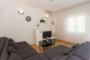 a living room with a couch and a tv at Apartment MATE in Kaštela