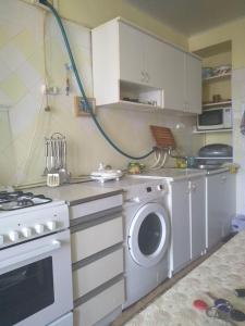 a kitchen with a stove and a washing machine at Guest House Armina in Yerevan