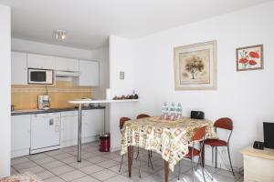 a kitchen with a table and chairs and a kitchen with white cabinets at ACCI le Palazzio in Cannes