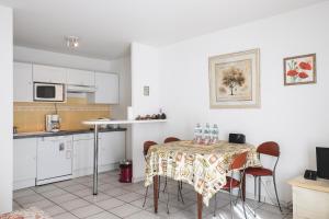 カンヌにあるACCI Cannes Palazzioのキッチン(テーブル、椅子付)、キッチン(白いキャビネット付)