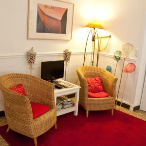 a living room with two chairs and a television at hotel de la plage in Piriac-sur-Mer