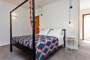 1 dormitorio con 1 cama con un edredón colorido en Idayvuelta Home & Suites, en Ses Salines