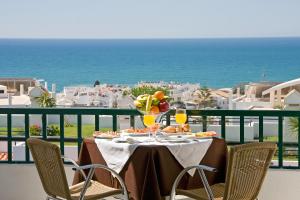 a table with food and drinks on a balcony with the ocean at Cerro Mar Atlantico & Cerro Mar Garden in Albufeira