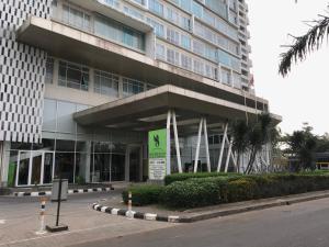 un grand bâtiment avec un panneau devant lui dans l'établissement Ruang Bravia Bogor Icon Hotel, à Bogor