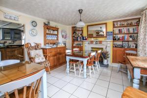 a kitchen with a table and chairs and a fireplace at Vine Cottage in Penpillick