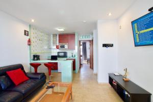 a living room with a couch and a kitchen at APARTMENT GOLDEN costa teguise in Costa Teguise