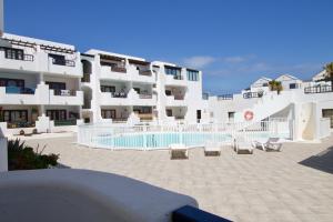 een groot appartementencomplex met een zwembad ervoor bij APARTMENT GOLDEN costa teguise in Costa Teguise