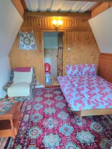 Poiana Stampeiにあるcasa paltin vila si cabaneのベッドと椅子付きの小さな部屋です。