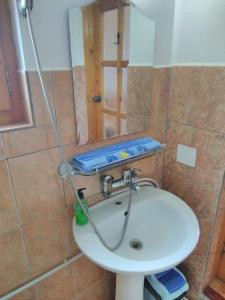 a white sink in a bathroom with a shower at casa paltin vila si cabane in Poiana Stampei