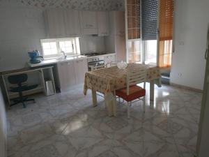 a kitchen with a table and a kitchen with white cabinets at TO & GI in Striano