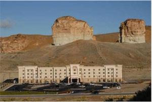 a large white building in front of a mountain at Hampton Inn & Suites Green River in Green River