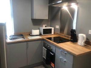 een keuken met een aanrecht met een magnetron bij Baxter Holiday Apartments in Blackpool