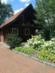 ein Haus mit einem Blumengarten davor in der Unterkunft Ferienhaus in Rumke in Bippen