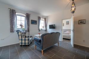 a living room with two chairs and a bedroom at Ferienwohnung Hooge Hörn in Borkum