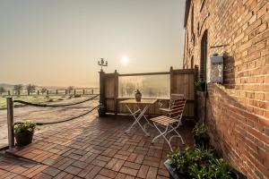 un patio con mesa y sillas junto a un edificio de ladrillo en Ferienwohnung HOOGE HÖRN im Ostland, en Borkum