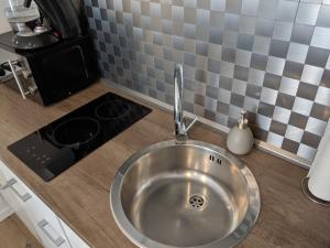 a stainless steel sink in a kitchen with a stove at 1 Zimmer Apartment Ratingen Ost in Ratingen