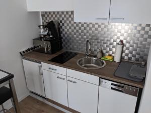 a small kitchen with a sink and a microwave at 1 Zimmer Apartment Ratingen Ost in Ratingen