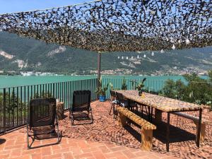 a patio with a table and chairs and a view of the water at Casitamia b&b in Clusane sul Lago