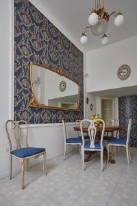 una sala da pranzo con tavolo, sedie e specchio di Il Piccolo Principe Affittacamere a Foligno