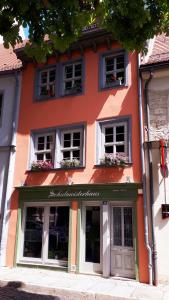 un edificio naranja con flores en las ventanas en Schulmeisterhaus en Naumburg