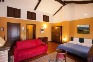 een slaapkamer met een bed en een rode bank bij Residenza Del Lago in Candia Canavese