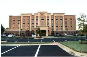 Luckney的住宿－傑克遜/弗洛伍德漢普頓酒店- 密西西比州機場區，一座大型建筑,前面设有停车场