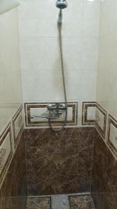 a shower with a hose in a tiled bathroom at Kazbek view guest house in Kazbegi