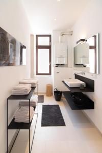 a white bathroom with a sink and a mirror at Casa Augusta - Urban Living in Trier