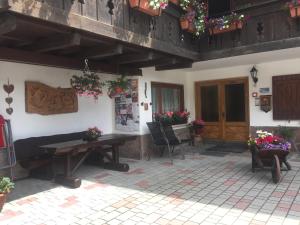 un patio con mesa de madera y sillas en un edificio en Garni La Vara, en Corvara in Badia