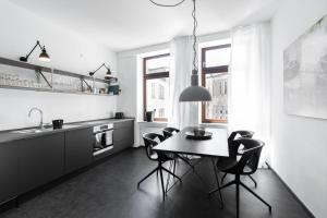a black and white kitchen with a table and chairs at Casa Augusta - Urban Living in Trier