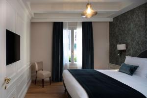 a bedroom with a bed and a tv and a window at Residenza Ducato in Venice