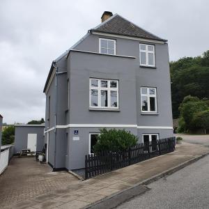 a gray house with a black fence in front of it at Siesta Vejle in Vejle