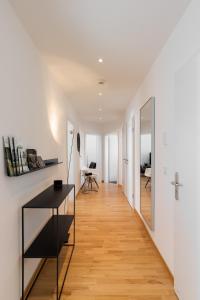 a hallway leading to a living room with a table and a mirror at Casa Augusta - Urban Living in Trier
