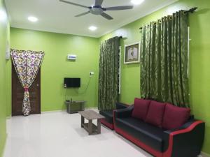 salon z kanapą i wentylatorem sufitowym w obiekcie HOMESTAY DAMAI YUSMILA w mieście Kuala Terengganu