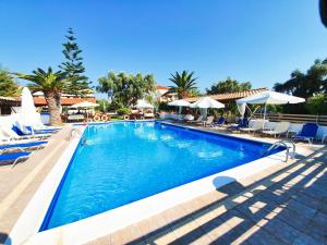 a swimming pool with chairs and umbrellas at a resort at Alexaria Holidays Homes in Lefkada