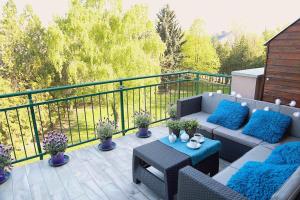 a patio with a couch and a table on a balcony at Monarchia Apartman Sunny in Mosonmagyaróvár