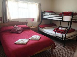 a bedroom with two bunk beds with towels on them at Chester Lodge in Sandown