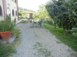 a gravel path with tables and chairs in a garden at La Colombarola in Farneto