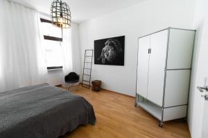 a bedroom with a bed and a white cabinet at Casa Augusta - Urban Living in Trier