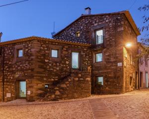 a large stone building with a light on at Casa De Janeiro in Janeiro de Cima