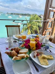 - une table avec une assiette de nourriture et une vue sur l'océan dans l'établissement Azure Beach Boutique Hotel, à Grand Baie