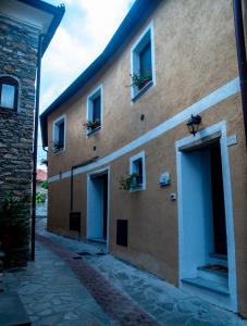 a building with two doors and two windows and flowers at Agriturismo De Ferrari in Onzo